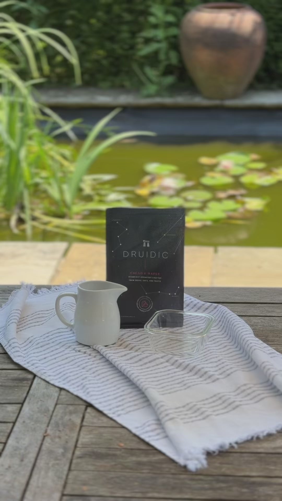 Video showing Druidic being prepared outside, with a lush garden in the background. Hands shake the pack, pour out a 50g portion of dry mix into a container on some scales, add 65-105ml of milk from a jug, stir and seal the container. A clock shows time passing to the words refrigerate overnight. Then there's a close up of Druidic's unique texture.